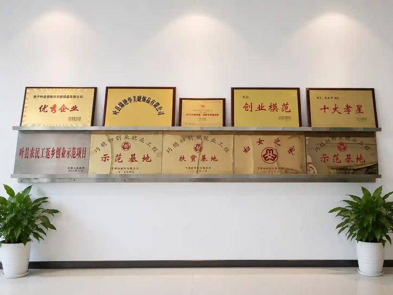 A row of JINYANHUA award certificates displayed on a shelf against a white wall