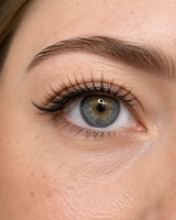 Close-up eye wearing black false eyelashes with small magnetic dot