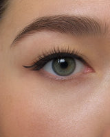 Thick, voluminous false eyelashes on one eye, long curled lash tips