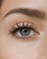 False eyelashes applied, close-up of eye with curled black lashes
