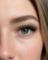 JINYANHUA 5D cluster lashes close-up with long curled tips on a light-colored eye