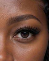 Close-up of an eye with thick black eyelash extensions and a defined lash line